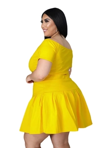 Detail of a bright yellow plus size two-piece set featuring off-shoulder top and pleated skirt
