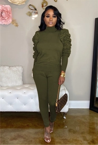 Close-up of ruched detailing on sleeves of a dark army green two-piece knit set