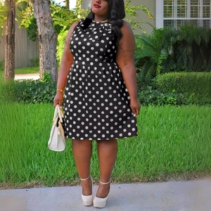 Vintage sleeveless black dress with large white polka dots and an elegant bow neckline