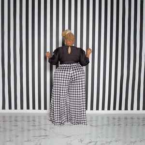 Detail view of high waist houndstooth wide-leg pants and black long sleeve back-neckline top