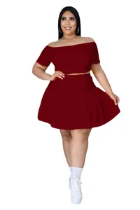 Detail of the high-waisted pleated mini skirt and off-shoulder crop top in deep red