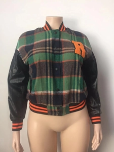 Detail of the green plaid varsity jacket featuring faux leather sleeves and letter R patch