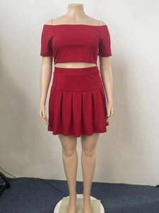 Detail of burgundy two-piece set featuring off-shoulder crop top and pleated mini skirt