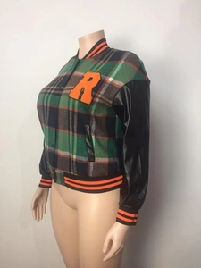 Detail of vintage patchwork jacket with plaid fabric, leather sleeves and orange embroidery