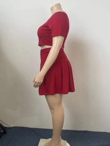 Side view of red two-piece set featuring off-shoulder crop top and pleated mini skirt