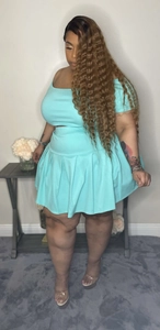 Detail of light blue off-shoulder top and high-waisted pleated skirt set for women