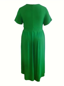 Back view of a vibrant green short-sleeve midi dress with waist-defining seam detail
