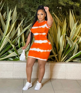 Außenaufnahme einer Frau in einem orange-weißen figurbetonten Tie-Dye Minikleid