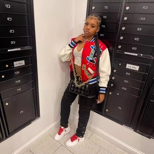 Red and white varsity jacket with letter embroidery and contrast ribbing on streetwear model