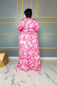 Detail of plus size long sleeve dress featuring vibrant pink floral prints and maxi hemline