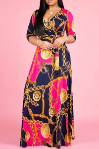 Detail of V-neck cross neckline with gold chain and medallion print on maxi dress