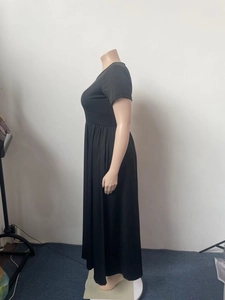 Detail of waist pleats and soft fabric texture on a black short sleeve maxi dress