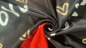 Detail of soft heart print fabric with vibrant red and black spiral textile texture
