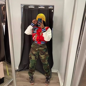 Ensemble streetwear avec veste baseball rouge à patchs et pantalon cargo camouflage