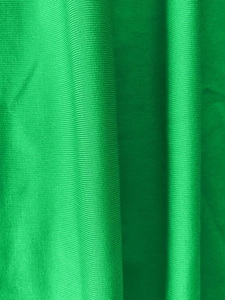 Close-up of bright green ribbed knit fabric texture with soft vertical drape