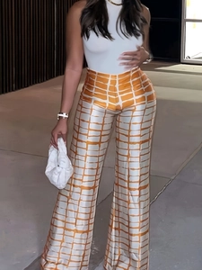 Détail d'un pantalon large à taille haute avec tissu en satin à carreaux orange et blanc