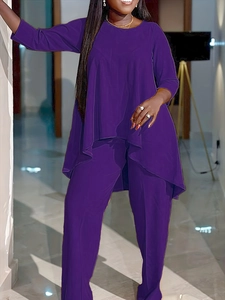 Détail d'un ensemble deux pièces violet avec haut asymétrique et pantalon assorti