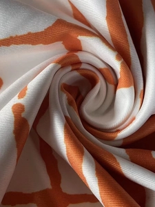 Gros plan sur le tissu à carreaux orange et blanc montrant la texture et les détails du motif