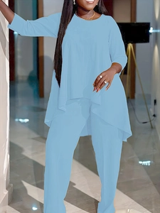 Détail d'un ensemble deux pièces bleu clair avec ourlet asymétrique et manches longues