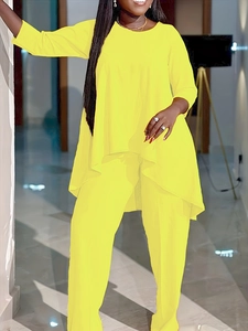 Détail d'un ensemble deux pièces jaune vif à manches longues avec ourlet asymétrique et pantalon
