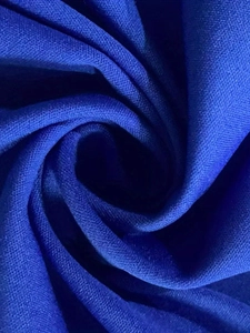 Close-up of royal blue knit fabric texture showing fine weave and silky glossy finish
