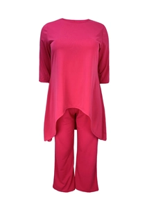 Détail d'un ensemble deux pièces rose fuchsia avec haut asymétrique et pantalon assorti