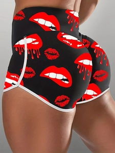 Close-up of high waist black yoga shorts featuring red lip prints and white trim