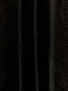 Vue macro du tissu en maille noire montrant un drapé doux et une texture textile fine