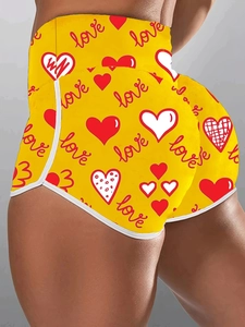 Detail of high waisted yellow fitness shorts with red heart print and white binding