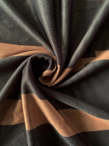 Détail du tissu en maille rayé aux motifs noir et marron avec un drapé en spirale