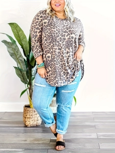 Detail view of plus size leopard print long sleeve top with distressed denim jeans