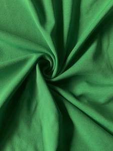 Dettaglio del tessuto a maglia verde brillante con drappeggio elegante per vestiti