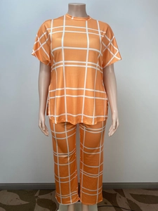 Detail view of orange plaid loungewear set featuring short sleeve top and straight trousers