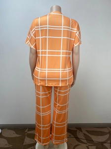 Rear view of bright orange grid print V-neck loungewear set on a mannequin