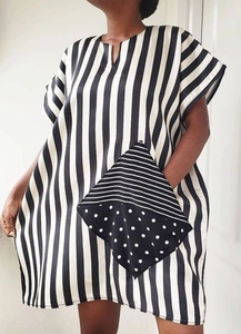 Detail of the oversized patchwork pocket with stripes and polka dots on a striped dress