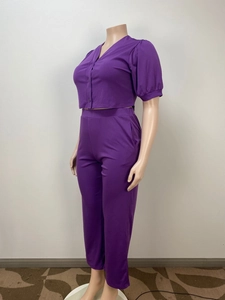 Detail view of purple short-sleeved V-neck top and matching trousers on a mannequin