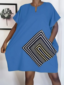 Detail of V-neckline and geometric black and white diamond pattern on loose blue dress