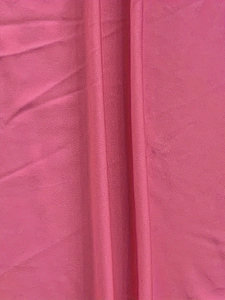 Macro view of rose red ribbed knit fabric with double stitching on a bodycon dress
