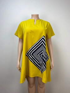 Detail of yellow loose plus size dress showing V-neck and black white geometric pattern