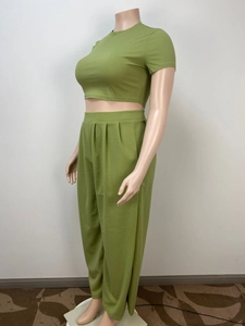 Detail of high-waisted wide-leg green trousers with pleated waist design for women