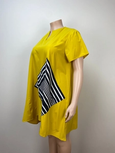 Detail of loose yellow short-sleeve dress with black and white striped diamond pattern