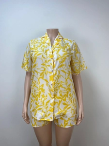 Detail of short sleeve button-up shirt and shorts with yellow leaf pattern print