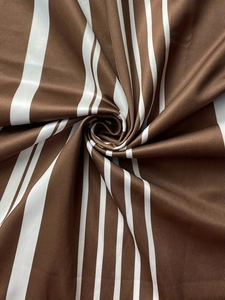 Detailed close-up of brown and white striped fabric with fine ribbed texture and satin sheen