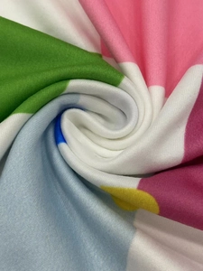 Detailed close-up of soft knit fabric texture featuring colorful abstract floral print