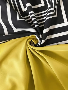 Close-up of geometric pattern silk dress fabric with black, white and yellow contrast