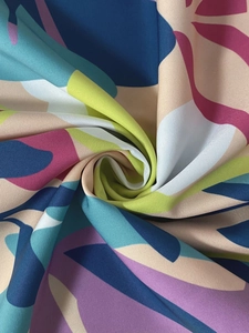 Detailed close-up of a vibrant floral print dress fabric with a spiral twist layout