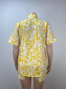 Detail of the back view of a white two-piece summer set with yellow leaf prints