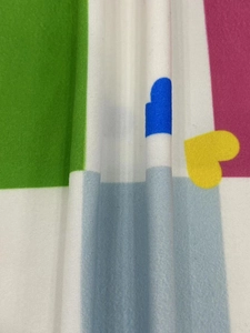 Close-up of soft knit fabric with colorful geometric patchwork and heart patterns