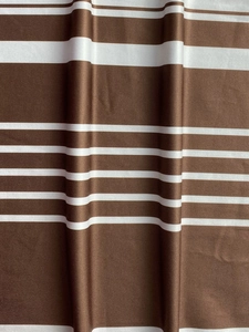 Close-up of brown and white striped fabric with ribbed texture and natural draping folds