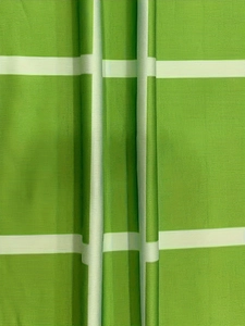 Detail of green and white grid fabric showing horizontal ribbed texture and soft drape